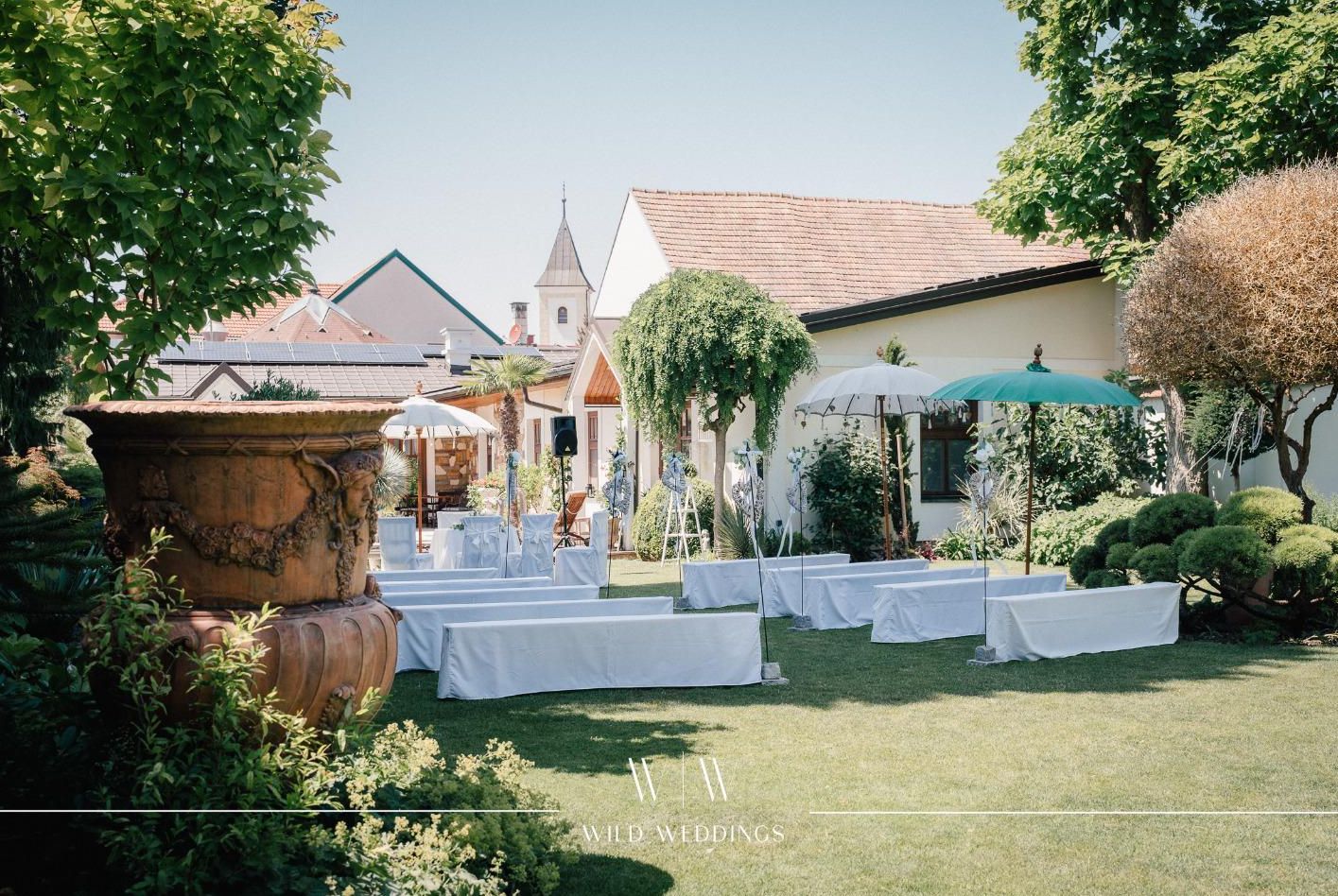 Der Garten vom Gasthaus Hirschbeck in Seibersdorf dekoriert für eine Hochzeit mit weißen Stühlen.